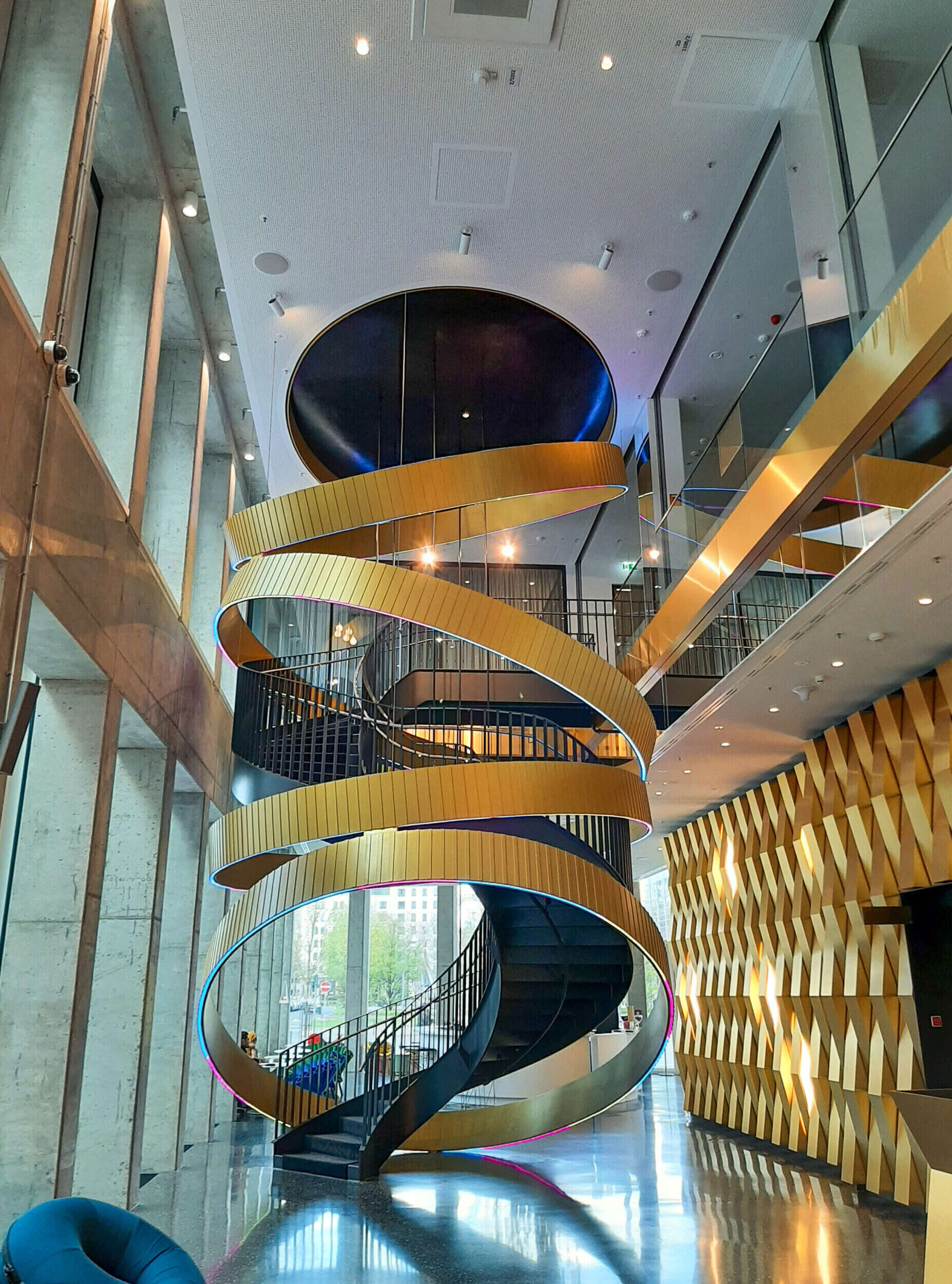 imposantes Foyer um die Treppe schlängeln sich goldene Riemen bis zur Decke
